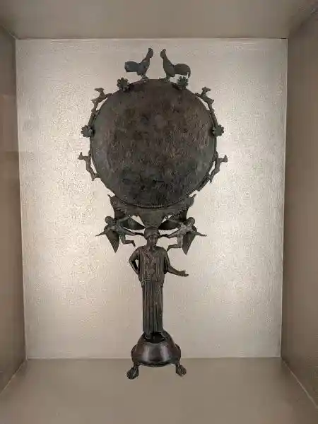 Ancient Greek bronze mirror with caryatid figure and dove decorations from Peloponnese workshop